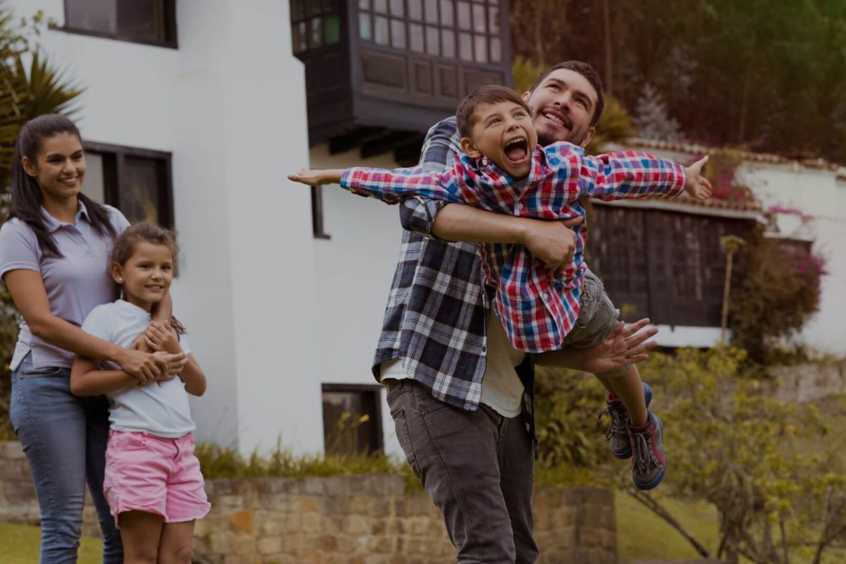 Happy family playing together outside a cozy countryside home during a UK getaway.