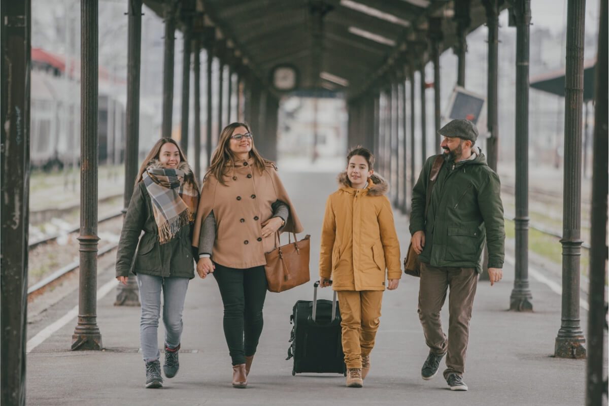 Family traveling with teens at a train station during a cozy UK trip.